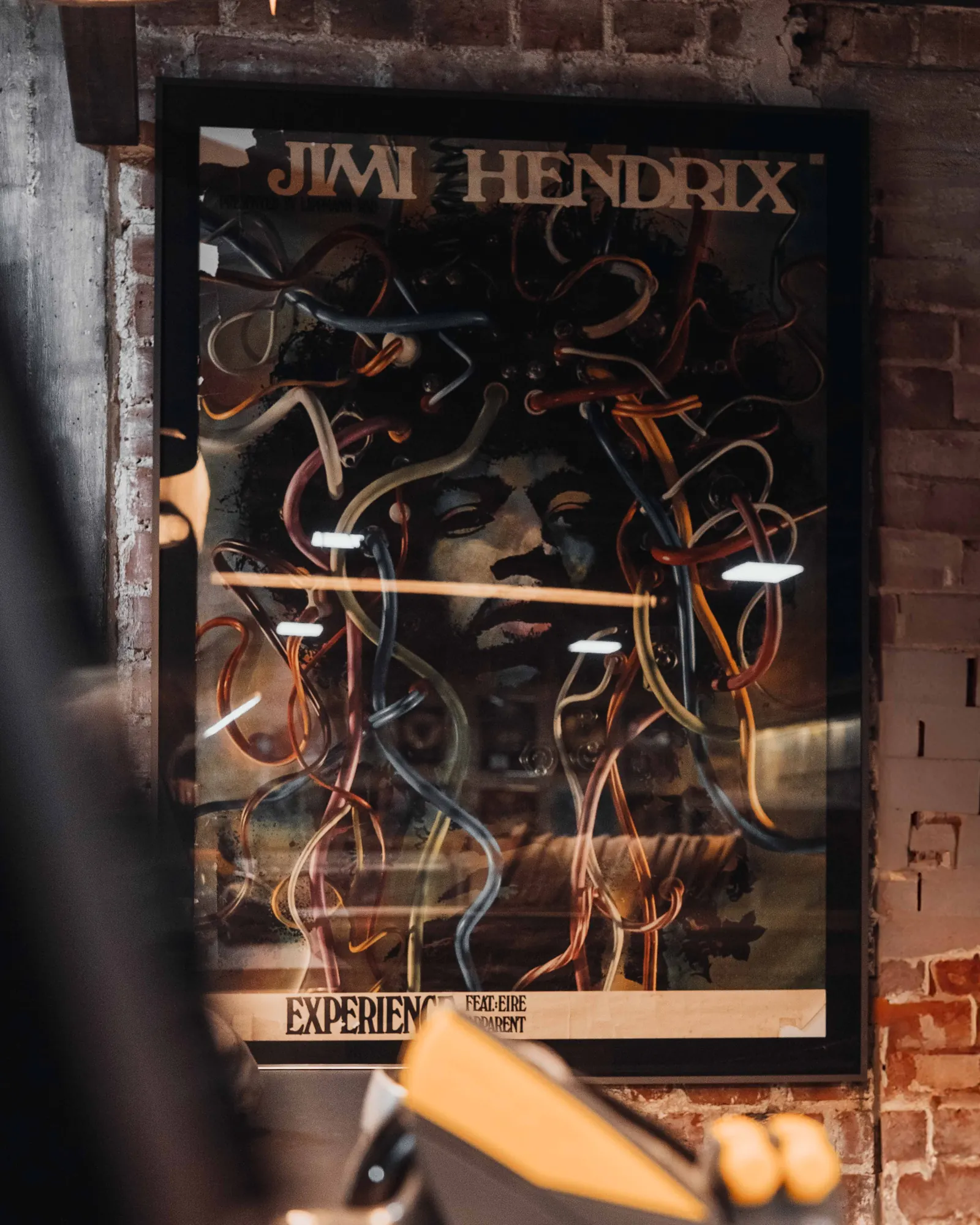 Gerahmtes Jimi-Hendrix-Poster an der Backsteinwand im Vinylkeller