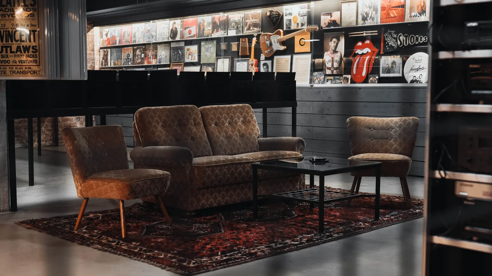 Gemütliche Sitzecke mit Vintage-Sofa vor einer Wand voller Plattencover